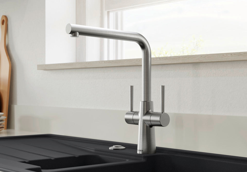 BLANCO Lax Dual Lever Kitchen Mixer Tap with 360° Swivel Spout in PVD Steel in Front of a Window