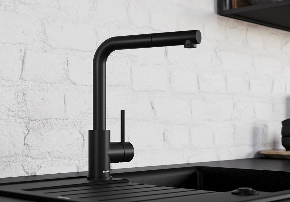 BLANCO Mila Eco-Flow Single Lever Kitchen Mixer Tap with 360° Swivel Spout in Black Matt against a White Brick Wall
