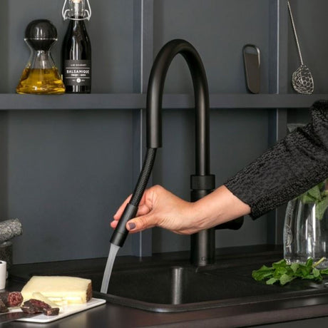 QUOOKER FLEX TAP in black in a modern kitchen setting demonstrating the pull out hose feature