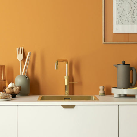 Quooker Fusion Square All-in-One Boiling Hot Cold Kitchen Tap Lifestyle  setting in a clean bright minimalistic orange coloured kitchen