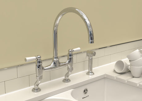 Charlbury kitchen handspray in chrome alongside a chrome bridge tap on a ceramic butler sink