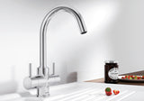 BLANCO Camia Dual Lever C-Shaped Kitchen Mixer Tap in Chrome on a White Sink Drainer